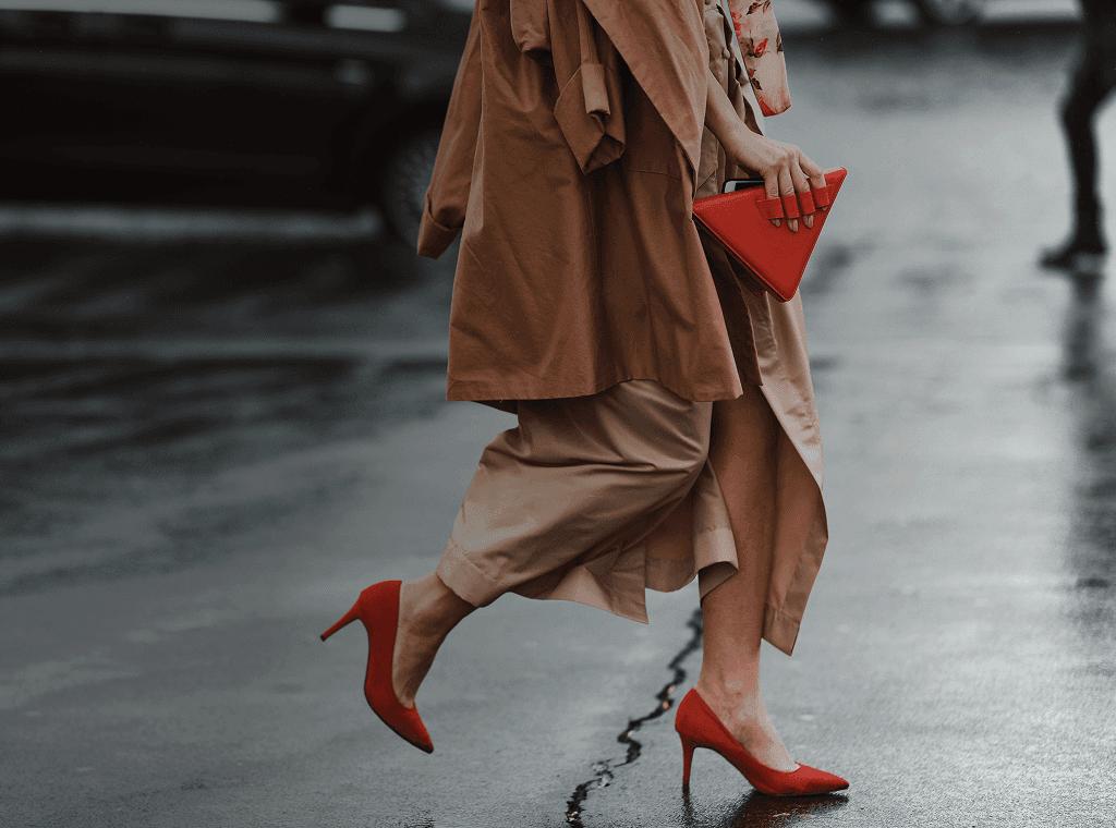 Well-dressed woman with beautiful red high heels and fashionable red handbag crosses the street. Overlaid is the French phrase "bien habillé" with its English translation, "well-dressed".