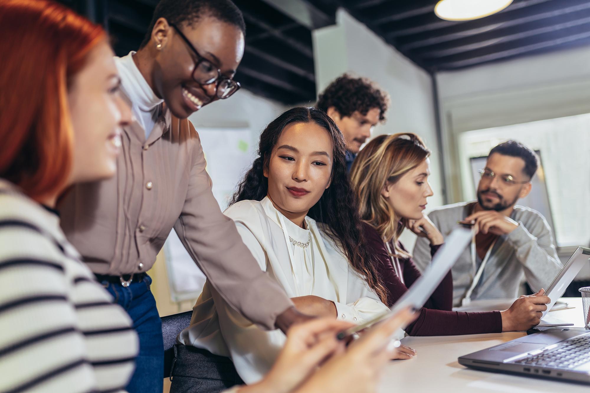 Group of professionals collaborating in a meeting, showcasing Rosetta Stone's language learning programs for enterprises to enhance communication and skills in the workplace.
