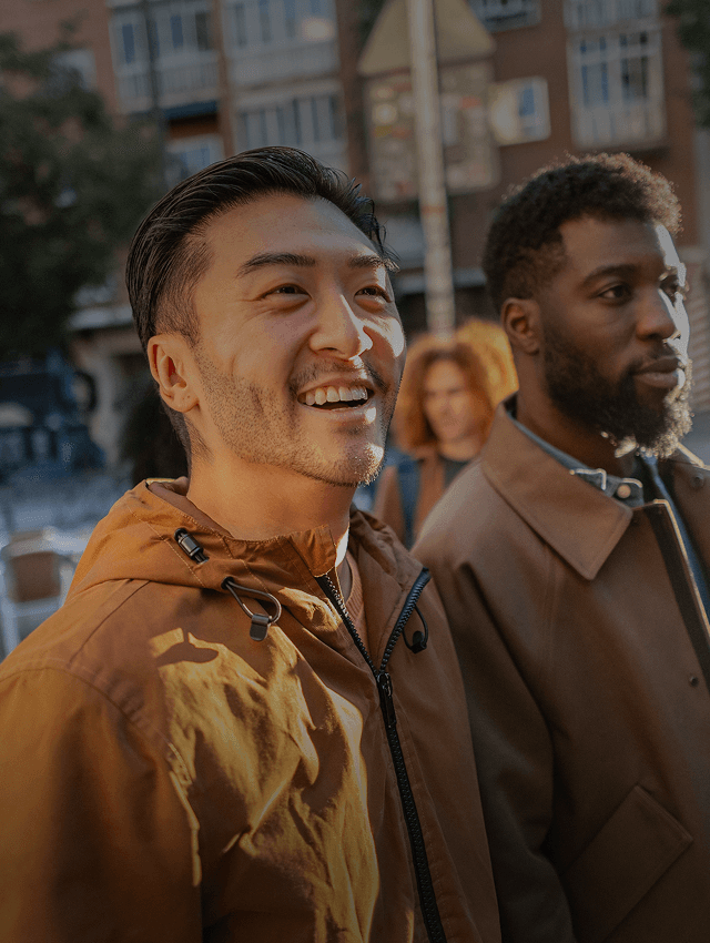 Smiling friends walk down a street in a new country.